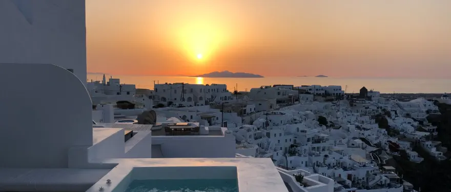 Whitewashed clifftop town at golden sunset with a plunge pool in Muscat, Oman