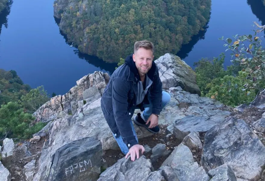 A traveler on a clifftop above the horseshoe bend of the Vltava river near Prague, Czech Republic