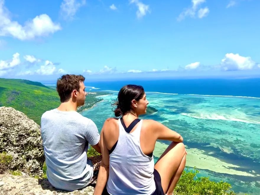 Two people looking out over the turquoise reef and coastline of Mauritius