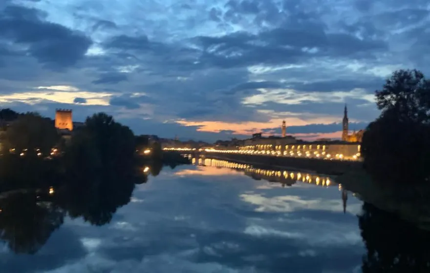 Blue-hour city lights reflected in the Arno river in Florence, Italy
