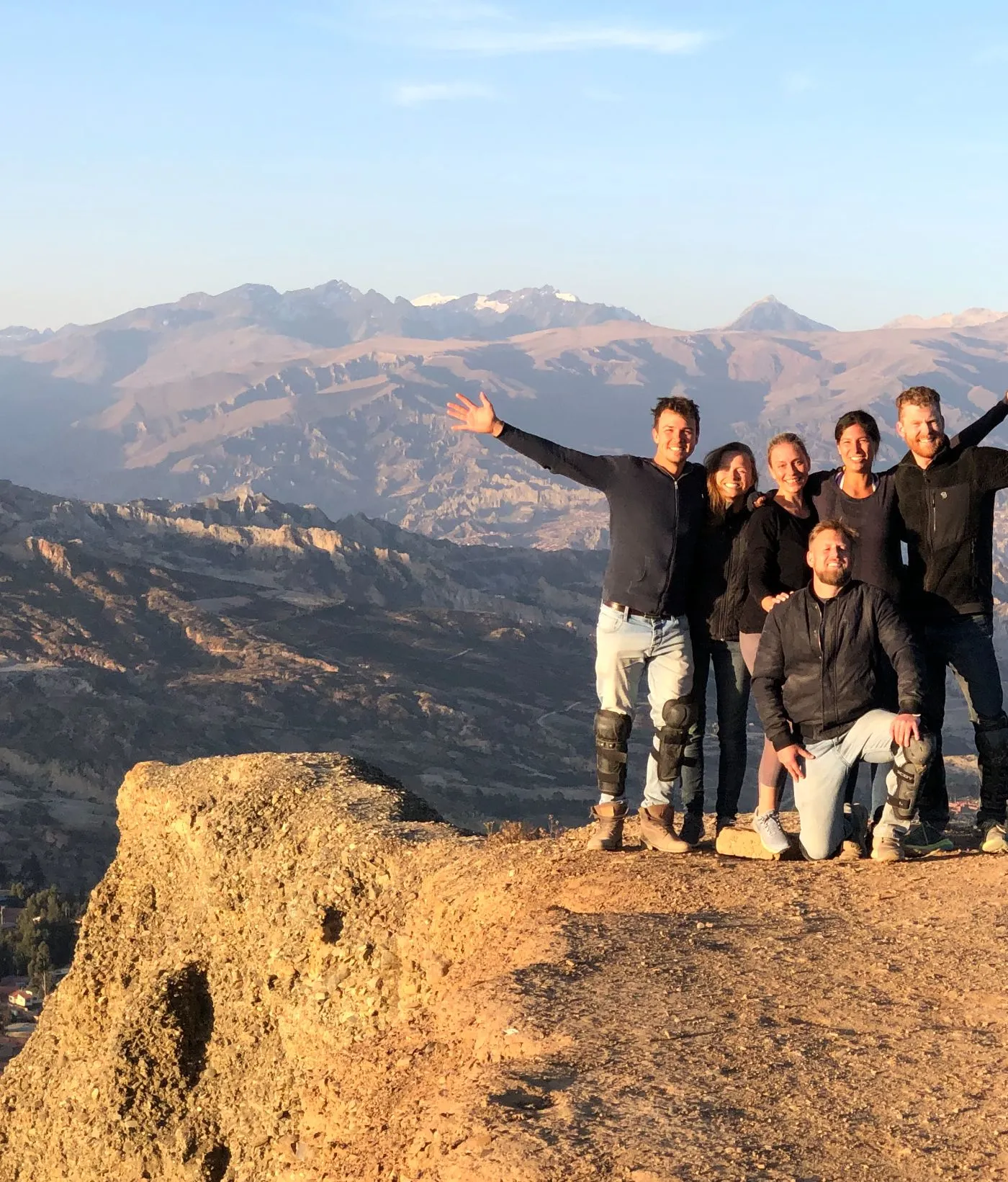 A group of travelers celebrating on a ridge above the valley in El Alto, Bolivia