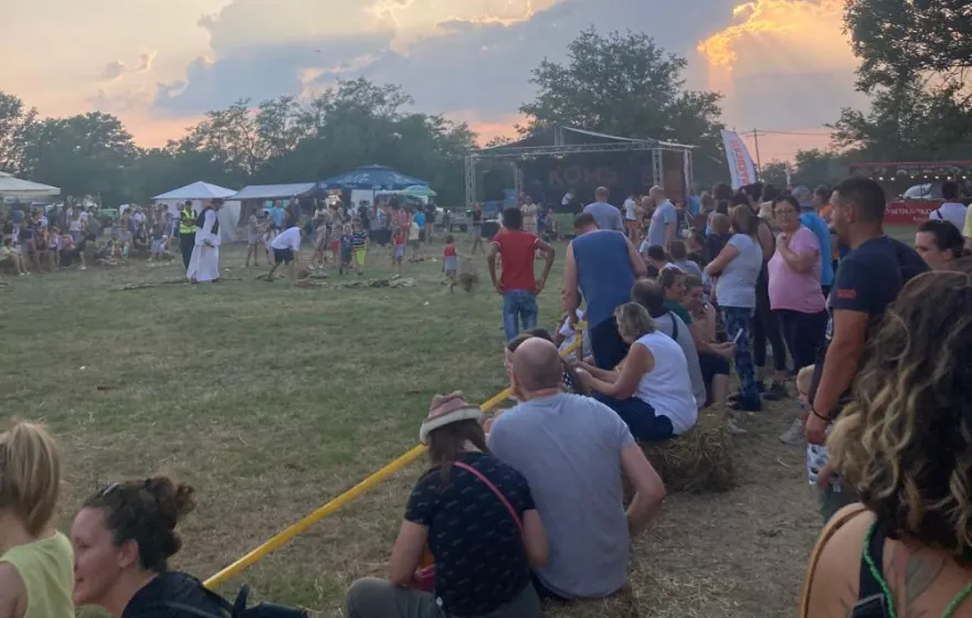 A festival crowd under sunbeams and dramatic clouds in Mokrin, Serbia